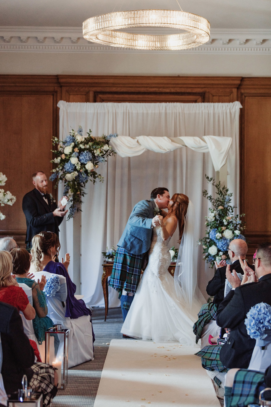 Bride and groom kiss at the altar at Dean Banks at The Pompadour while guests clap